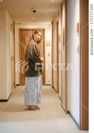 一位身穿浴衣的女子在日式旅館的走廊回頭望去。 一位身穿浴衣的女子在日式旅館的走廊回頭望去。 133727169