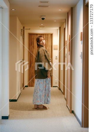 A woman in a yukata looking back in the corridor of a ryokan A woman in a yukata looking back in the corridor of a ryokan 133727170