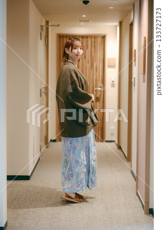 一位身穿浴衣的女子在日式旅館的走廊回頭望去。 133727173