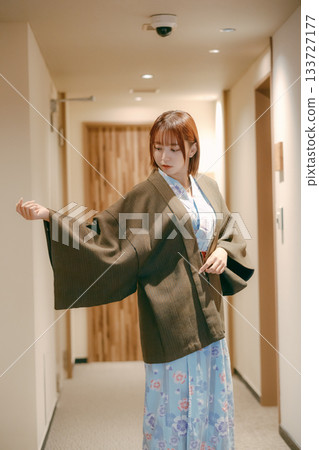 一位身穿浴衣的女子在日式旅館的走廊回頭望去。 一位身穿浴衣的女子在日式旅館的走廊回頭望去。 133727177