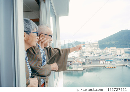 一對穿著浴衣的老夫婦正望著窗外的街景。 133727331