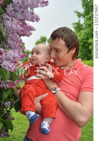 Father Showing Baby Lilac Flowers Up Close in Spring Father Showing Baby Lilac Flowers Up Close in Spring 133727667