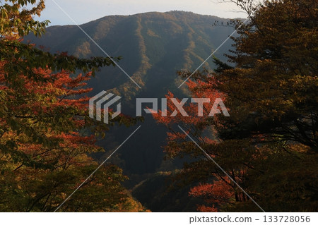 The majestic mountain range of Namego Valley framed by fiery autumn leaves 133728056