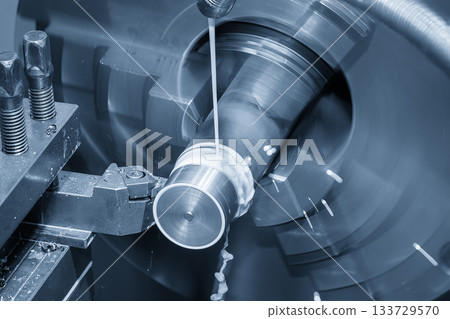 The lathe machine finish cut metal shaft parts with liquid coolant method in the light blue scene. The lathe machine finish cut metal shaft parts with liquid coolant method in the light blue scene. 133729570