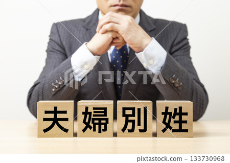 A block with the words "separate surnames for married couples" written on it and a businessman 133730968