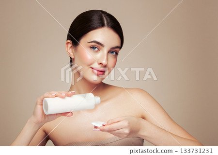 Young woman cleansing face with cosmetic milk Young woman cleansing face with cosmetic milk 133731231