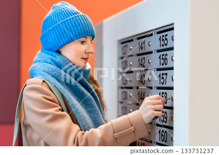 Woman opens a mailbox Woman opens a mailbox 133731237