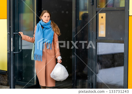 Young woman goes for a walk in the yard and takes out the trash 133731243