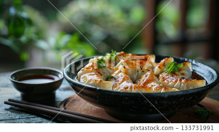 A Delicious and Appetizing Plate of Golden Brown Dumplings Beautifully Garnished with Fresh Chives and Sauce 133731991