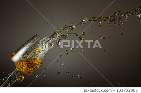 Glass and white wine splash on a beige background. 133732068