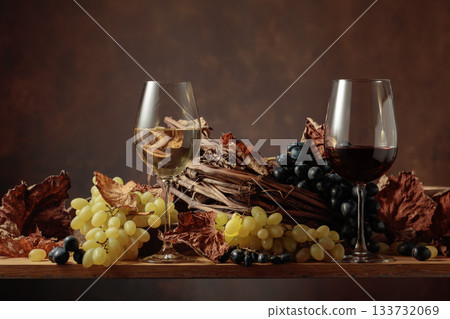 Glasses of white and red wine with bunches of grapes on wooden table. Glasses of white and red wine with bunches of grapes on wooden table. 133732069