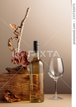 Bottle of white wine with a composition of old plank, dry snags, and dried vine leaves. Bottle of white wine with a composition of old plank, dry snags, and dried vine leaves. 133732073