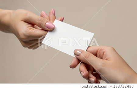 Two female hands exchanging a blank, white business card. Professional exchange, or business communication concept 133732483