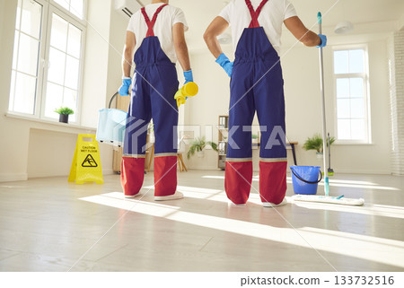 Legs of a team of cleaning service in uniform going to wash the floor with detergent 133732516