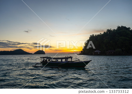 Boat at sunset on Bolilanga Island, Togian archipelago, Sulawesi, Indonesia 133733312