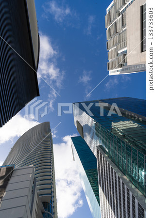 Modern glass building. Skyscraper in city. City downtown with skyscraper. Office building in business district. Skyscraper building architecture. Business skyscraper of glass. High perspective Modern glass building. Skyscraper in city. City downtown with skyscraper. Office building in business district. Skyscraper building architecture. Business skyscraper of glass. High perspective 133733603