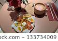 Smoked salmon waffle plate and pink latte with gold sprinkles 133734009