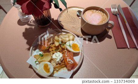 Smoked salmon waffle plate and pink latte with gold sprinkles Smoked salmon waffle plate and pink latte with gold sprinkles 133734009