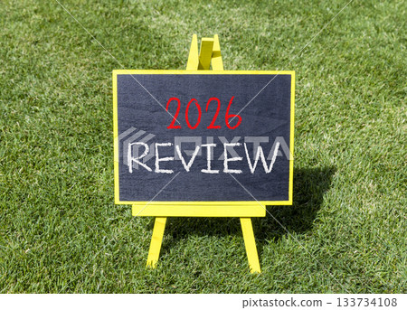 2026 Review symbol. Concept words 2026 Review on beautiful black blackboard. Beautiful green grass background. Business and 2026 review concept. Copy space. 133734108