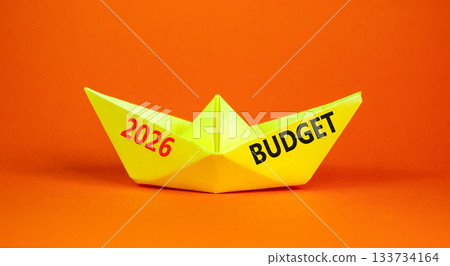 2026 Budget symbol. Concept words 2026 Budget on beautiful yellow paper boat. Beautiful orange paper background. Business and 2026 budget concept. Copy space. 2026 Budget symbol. Concept words 2026 Budget on beautiful yellow paper boat. Beautiful orange paper background. Business and 2026 budget concept. Copy space. 133734164