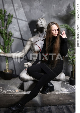 Serene female performer taking break beside stone monument 133734243