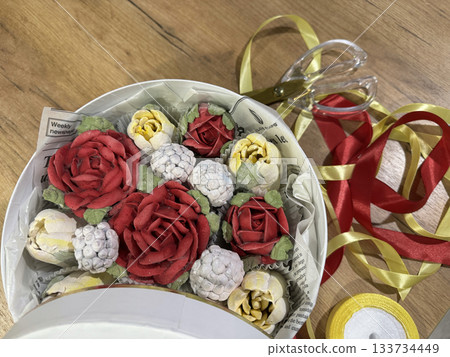 Homemade marshmallow in a hat box, Marshmallow flowers, tulips and roses, Packaging ribbons lie on the table nearby 133734449