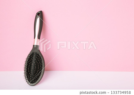 Massage hairbrush on pink background. Space for text 133734958