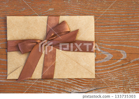 Gift certificate with an elegant bow on a wooden background Gift certificate with an elegant bow on a wooden background 133735303