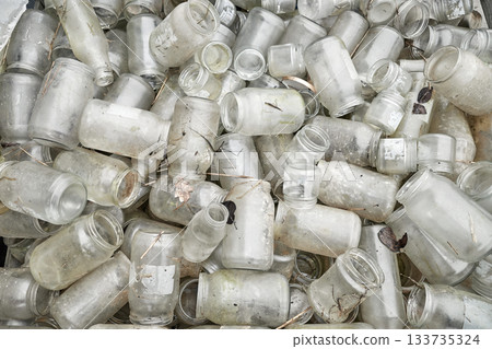 Photo of dirty, used glass jars and bottles. 133735324