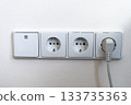 Electrical outlets and light switch on the wall 133735363
