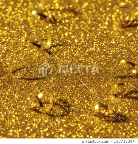 Vibrant gold glitter background: Festive serpentine ribbons texture 133735394