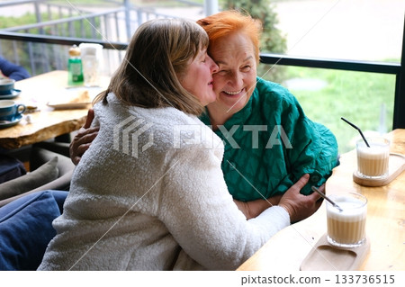 cafe drinking coffee woman and adult daughter elderly woman Portrait of old peasant woman with smiling daughter wearing typical Colombian clothes. Women with brown skin. 133736515