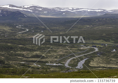 Road E6 winds through the scenic Dovrefjell Sunndalsfjella National Park in Norway's beautiful landscape 133736739