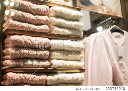 winter clothes women's sweater on hangers in a store in a shopping center window 133736910