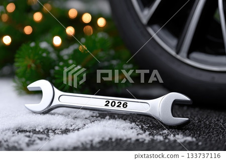 Metal wrench marked 2026 in winter setting with snow and lights 133737116