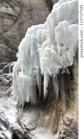 Frozen Icicle Cliff Partnachklamm: Dramatic Ice Formations Cascading Over Rugged Rock Wall by Water Frozen Icicle Cliff Partnachklamm: Dramatic Ice Formations Cascading Over Rugged Rock Wall by Water 133737595