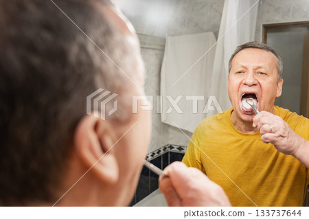 Rinsing mouth with water after brushing teeth and cleans tongue , caucasian adult male completing morning oral hygiene at home sink. Man Brushing Teeth Rinsing mouth with water after brushing teeth and cleans tongue , caucasian adult male completing morning oral hygiene at home sink. Man Brushing Teeth 133737644