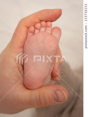 A close-up of a babys tiny foot held gently by an adult hand. The soft lighting and warm tones highlight tenderness, bonding and the intimate connection between parent and newborn, ideal for family A close-up of a babys tiny foot held gently by an adult hand. The soft lighting and warm tones highlight tenderness, bonding and the intimate connection between parent and newborn, ideal for family 133738153