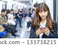 一位職業婦女在通勤列車上用智慧型手機觀看影片。 133738215