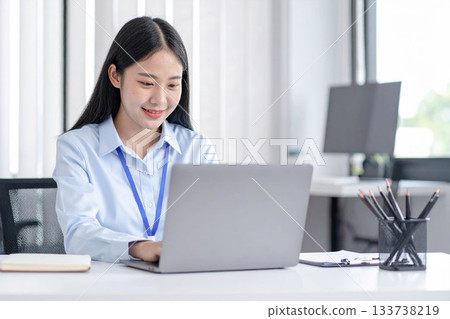 A woman in her twenties working on a computer 133738219