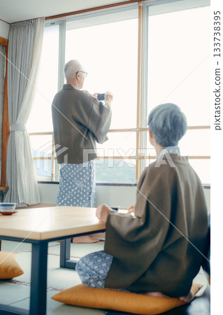 一對老年夫婦在傳統的日式旅館用智慧型手機拍攝風景。 133738395