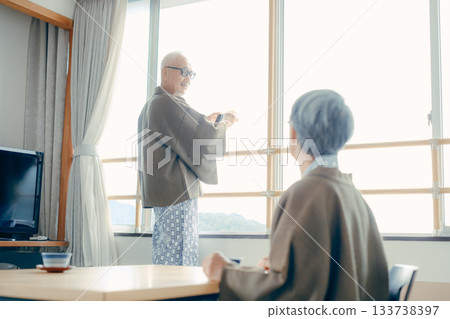 一對老年夫婦在傳統的日式旅館用智慧型手機拍攝風景。 133738397