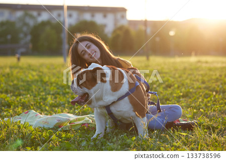 Young brunette girl play with her british bulldog Young brunette girl play with her british bulldog 133738596
