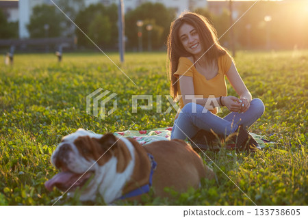 Young brunette girl play with her british bulldog Young brunette girl play with her british bulldog 133738605