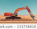 Bright orange excavator digging into dry desert soil with mountains and dunes in the background 133738816