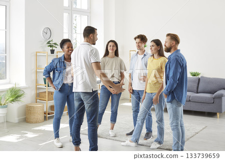 Group of diverse friends standing in the living room at home and having a discussion 133739659