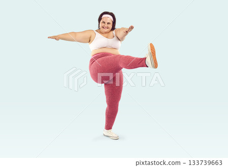 Happy overweight woman doing doing leg swing exercise during her fitness workout Happy overweight woman doing doing leg swing exercise during her fitness workout 133739663
