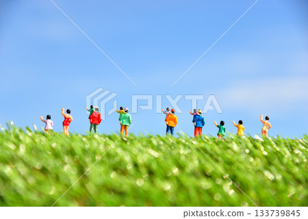 Image of people waving under a blue sky 133739845
