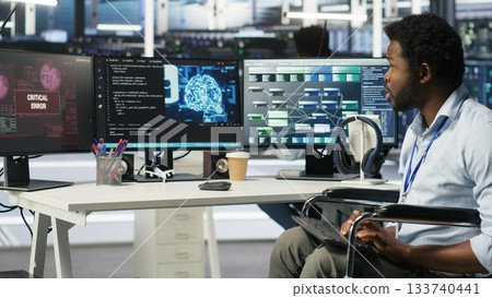 Stressed engineer with paraplegia in data center panicked by AI node tree software critical error. Anxious server hub worker in wheelchair worried by visual programming tool glitching, camera B Stressed engineer with paraplegia in data center panicked by AI node tree software critical error. Anxious server hub worker in wheelchair worried by visual programming tool glitching, camera B 133740441