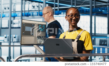 Portrait of happy engineer in smart photovoltaics factory looking at system performance metrics. Cheerful worker in solar panels plant tracking energy production through IoT sensors, camera A Portrait of happy engineer in smart photovoltaics factory looking at system performance metrics. Cheerful worker in solar panels plant tracking energy production through IoT sensors, camera A 133740477
